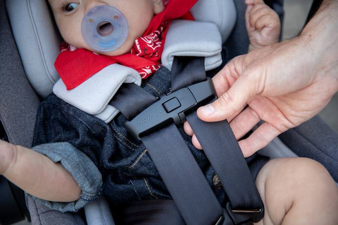 Baby in car seat with harness