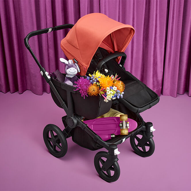 A Bugaboo Donkey 5 Mono with multiple toys and items in the side luggage basket and underseat basket.