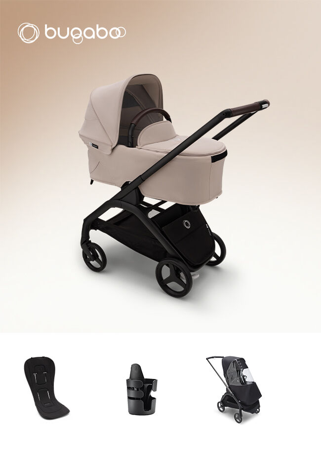Un carrito compacto Bugaboo Dragonfly con un capazo, mostrado con varios accesorios de bebé en el pack