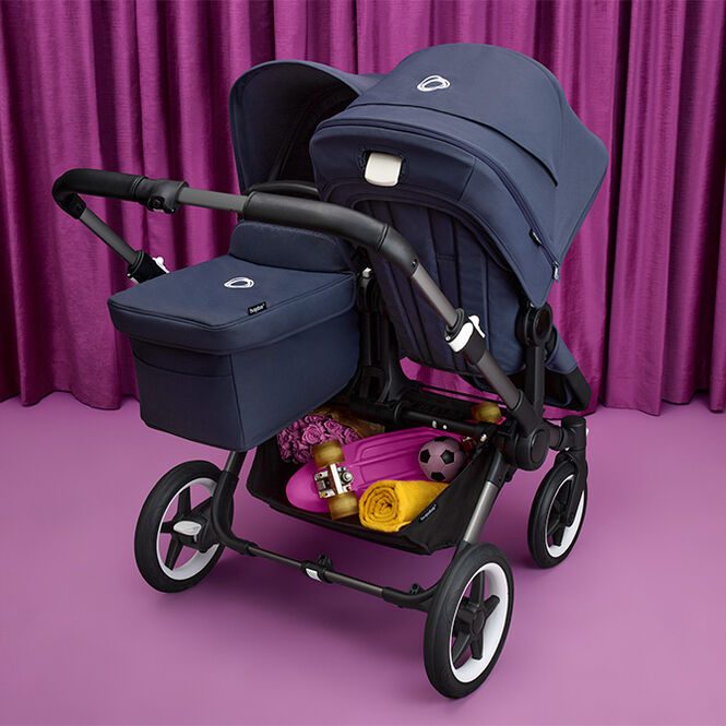 A Donkey 5 Duo with seat and bassinet, with multiple toys and items in the underseat basket.