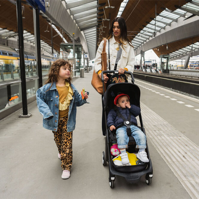 Women walking in subway station with two kids