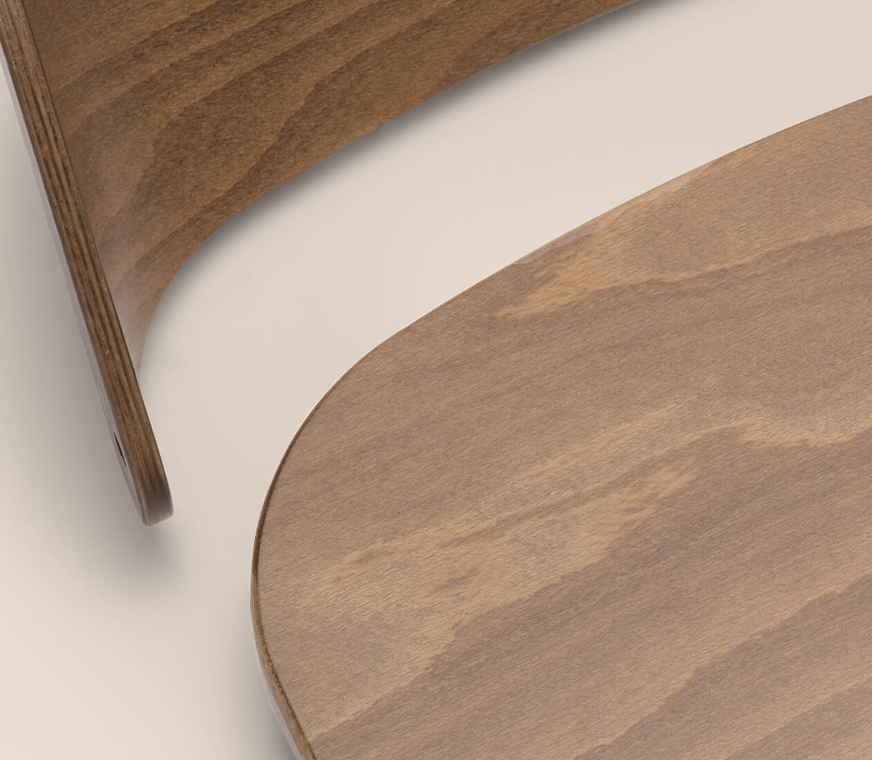 Close up on the Bugaboo Giraffe chair, showing part of the wooden seat and backrest.
