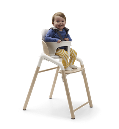 Enfant en bas âge dans une chaise haute Bugaboo Giraffe avec un kit bébé.