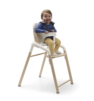Toddler in a Bugaboo Giraffe high chair with baby set.