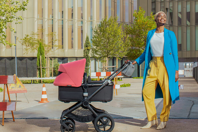 Mom walking her baby outside in a bassinet stroller