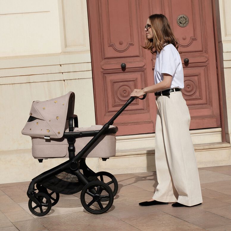 Un papà e sua figlia sono chinati in un giardino selvaggio e incolto. Lui le mostra qualcosa che ha tra le mani.