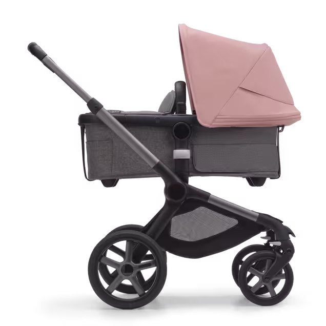 Side view of the Bugaboo Fox 5 carrycot pushchair with graphite chassis, grey melange fabrics and morning pink sun canopy. - Main Image Slide 2 of 13