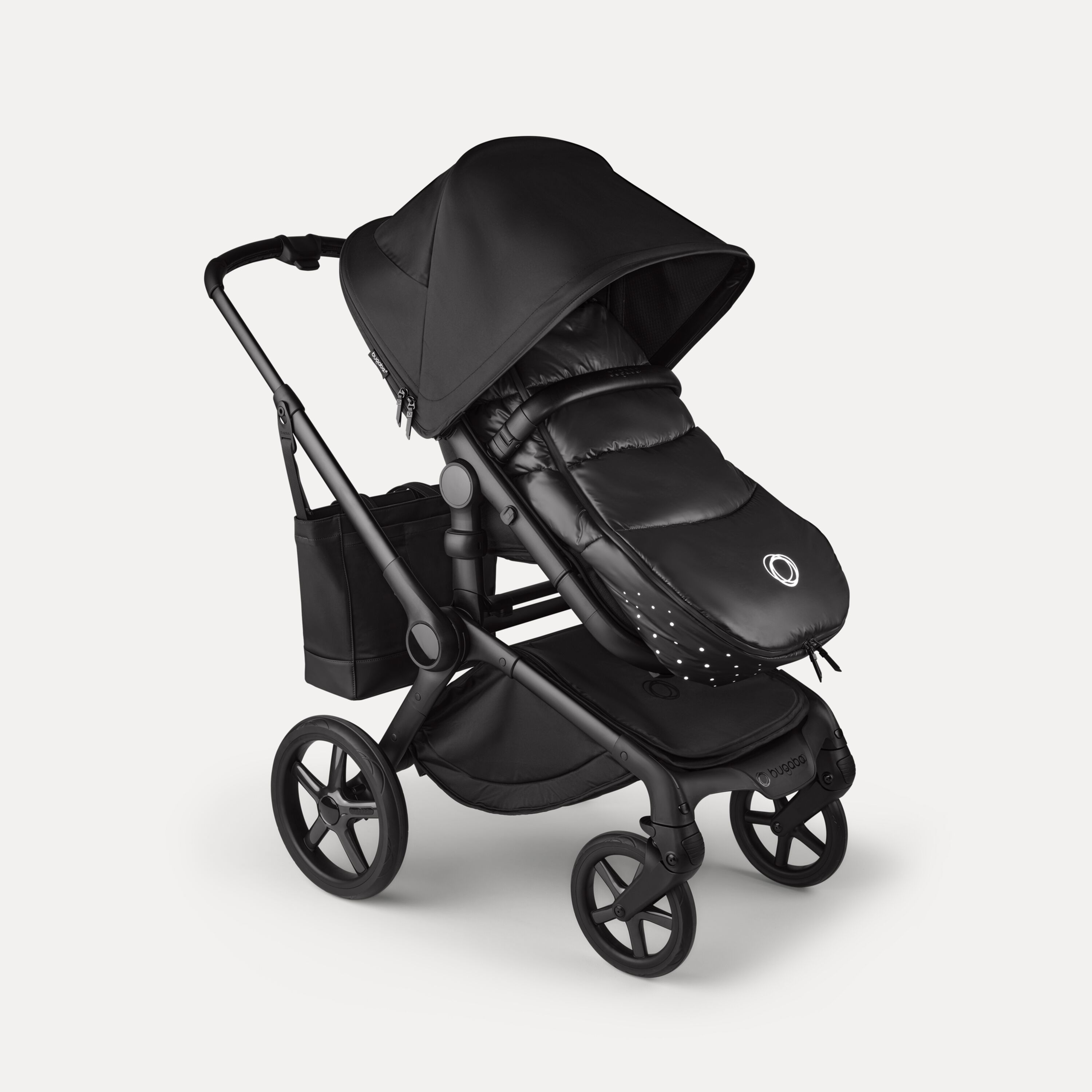A Bugaboo Fox 5 Noir Limited Edition stroller with a footmuff and changing bag, all in the Black Moonlight colorway. - Main Modal Image Slide 15 of 15