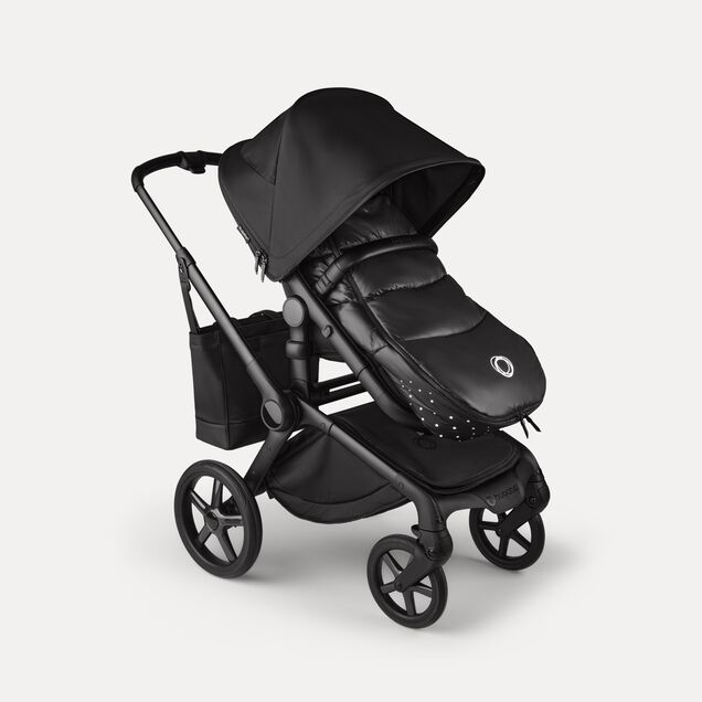 A Bugaboo Fox 5 Noir Limited Edition stroller with a footmuff and changing bag, all in the Black Moonlight colorway. - Main Image Slide 15 of 15