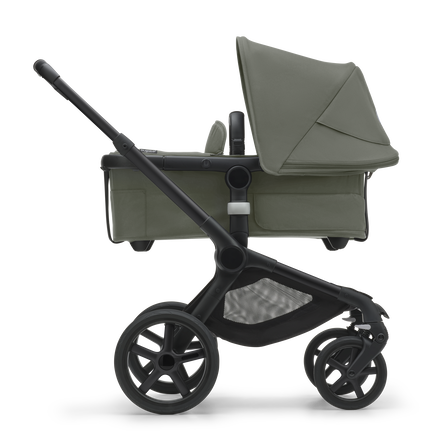 Side view of the Bugaboo Fox 5 bassinet stroller with black chassis, forest green fabrics and forest green sun canopy.