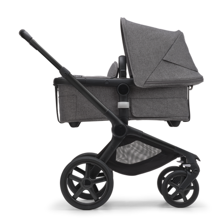 Side view of the Bugaboo Fox 5 bassinet stroller with black chassis, grey melange fabrics and grey melange sun canopy.