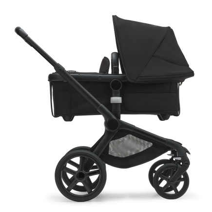 Side view of the Bugaboo Fox 5 bassinet pram with black chassis, forest green fabrics and forest green sun canopy.