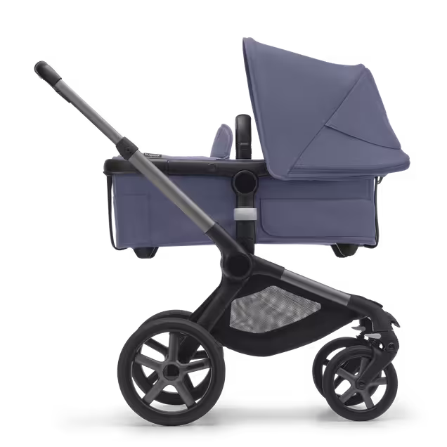 Vue latérale de la Bugaboo Fox 5 avec nacelle, châssis graphite, habillage bleu tonnerre et capote bleu tonnerre. - Main Image Slide 2 of 13