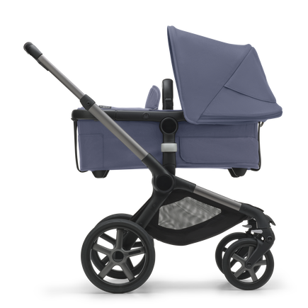 Side view of the Bugaboo Fox 5 bassinet stroller with graphite chassis, stormy blue fabrics and stormy blue sun canopy.