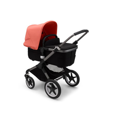 Bugaboo Fox 3 carrycot pushchair with graphite frame, black fabrics, and red sun canopy.