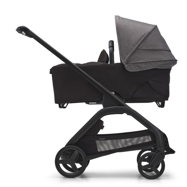 Side view of the Bugaboo Dragonfly bassinet stroller with black chassis, midnight black fabrics and grey melange sun canopy.