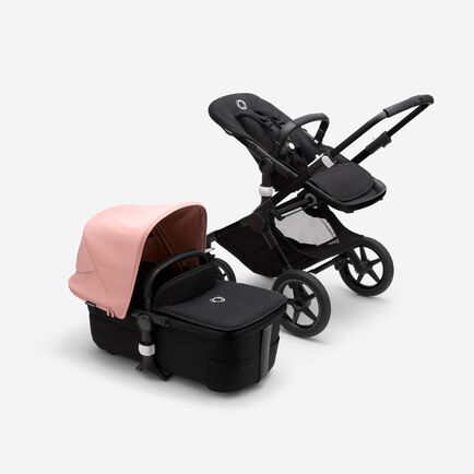 Bugaboo Fox 3 bassinet and seat stroller with black frame, black fabrics, and pink sun canopy.