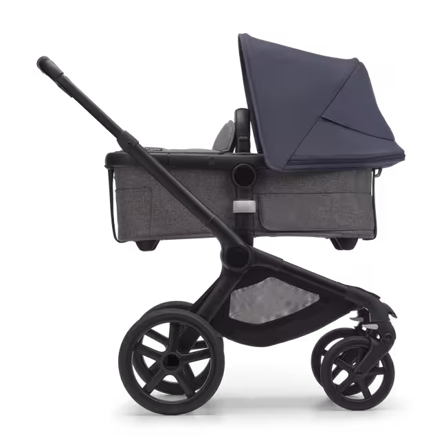 Side view of the Bugaboo Fox 5 carrycot pushchair with black chassis, grey melange fabrics and stormy blue sun canopy. - Main Image Slide 2 of 13