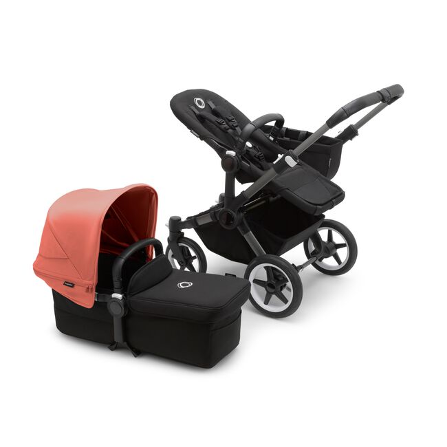 Bugaboo Donkey 5 Mono seat stroller with graphite chassis and midnight black fabrics, plus bassinet with sunrise red sun canopy.