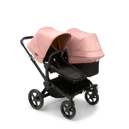 Bugaboo Donkey 5 Duo seat and bassinet stroller with black chassis, midnight black fabrics and morning pink sun canopy.