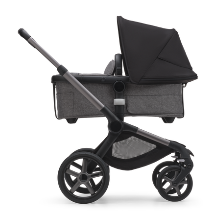 Side view of the Bugaboo Fox 5 bassinet stroller with graphite chassis, grey melange fabrics and midnight black sun canopy.