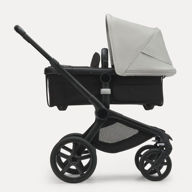Zijaanzicht van de Bugaboo Fox 5 kinderwagen met wieg met black onderstel, midnight black bekleding en misty white zonnekap. - Main Image Slide 2 van 12