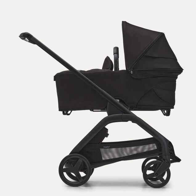 Side view of the Bugaboo Dragonfly carrycot pushchair with black chassis, midnight black fabrics and midnight black sun canopy. - Main Image Slide 3 of 16
