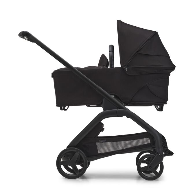 Side view of the Bugaboo Dragonfly carrycot pushchair with black chassis, midnight black fabrics and midnight black sun canopy. - Main Image Slide 4 of 18