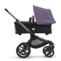 Side view of the Bugaboo Fox 5 carrycot pushchair with graphite chassis, midnight black fabrics and astro purple sun canopy.
