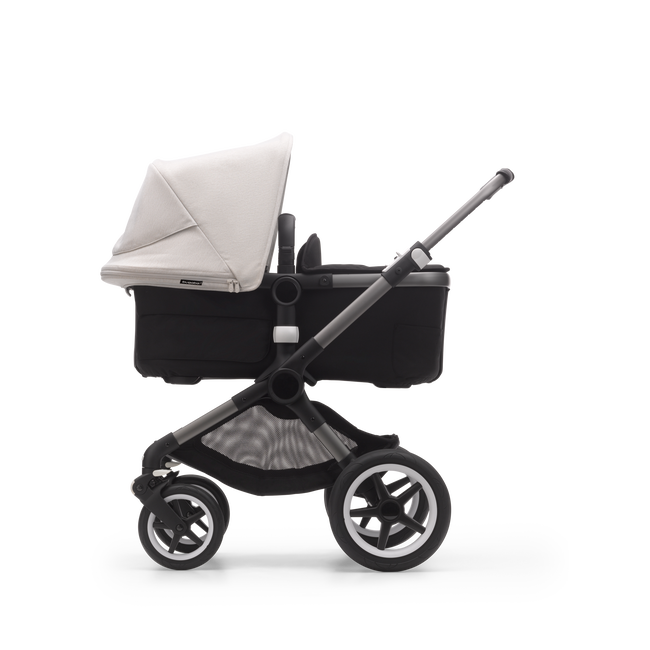Side view of a Bugaboo Fox 3 bassinet stroller with graphite frame, black fabrics, and white sun canopy.
