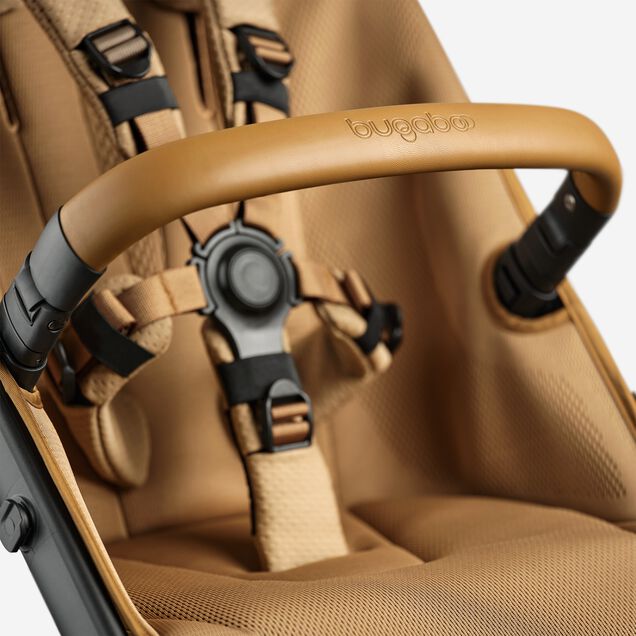 A close up of the bumper bar and seat of the Bugaboo Fox 5 Noir Limited Edition Amber Glow. - Main Image Slide 13 of 15