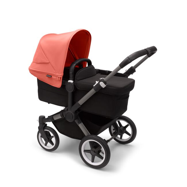 Bugaboo Donkey 5 Mono bassinet stroller with graphite chassis, midnight black fabrics and sunrise red sun canopy.