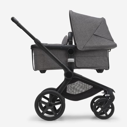 Side view of the Bugaboo Fox 5 bassinet stroller with black chassis, grey melange fabrics and grey melange sun canopy.
