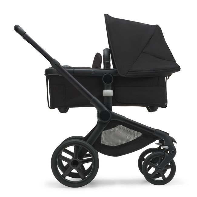 Side view of the Bugaboo Fox 5 carrycot pushchair with black chassis, midnight black fabrics and midnight black sun canopy.
