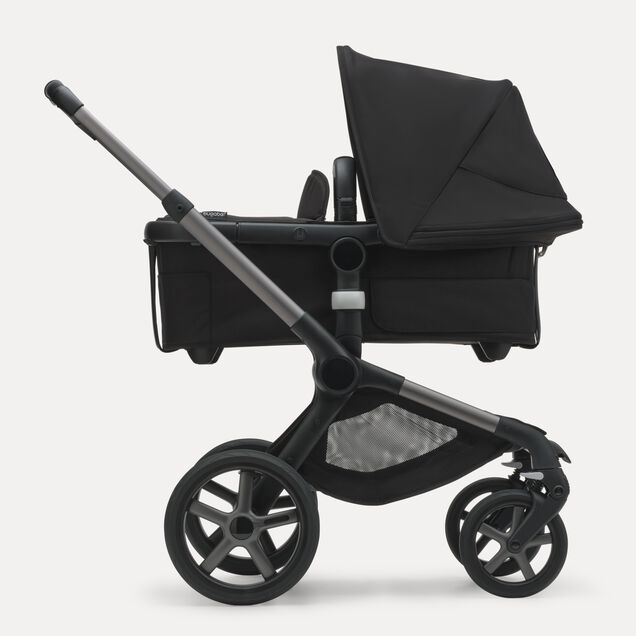 Side view of the Bugaboo Fox 5 bassinet stroller with graphite chassis, midnight black fabrics and midnight black sun canopy. - Main Image Slide 2 of 13