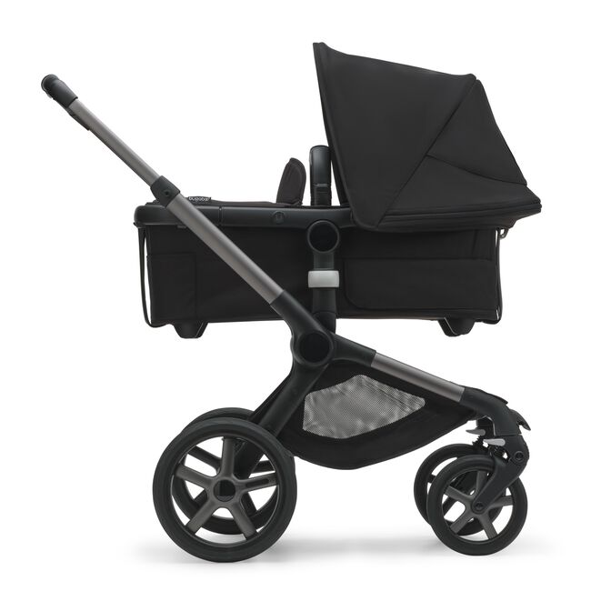 Side view of the Bugaboo Fox 5 bassinet stroller with graphite chassis, midnight black fabrics and midnight black sun canopy.