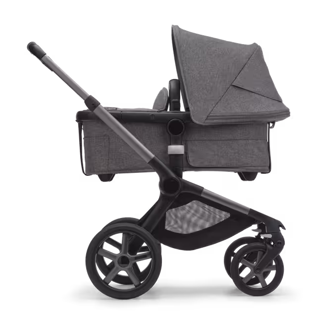 Side view of the Bugaboo Fox 5 bassinet pram with black chassis, forest green fabrics and forest green sun canopy. - Main Image Slide 2 of 12