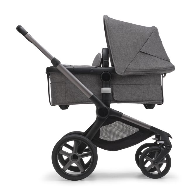 Side view of the Bugaboo Fox 5 bassinet pram with black chassis, forest green fabrics and forest green sun canopy.
