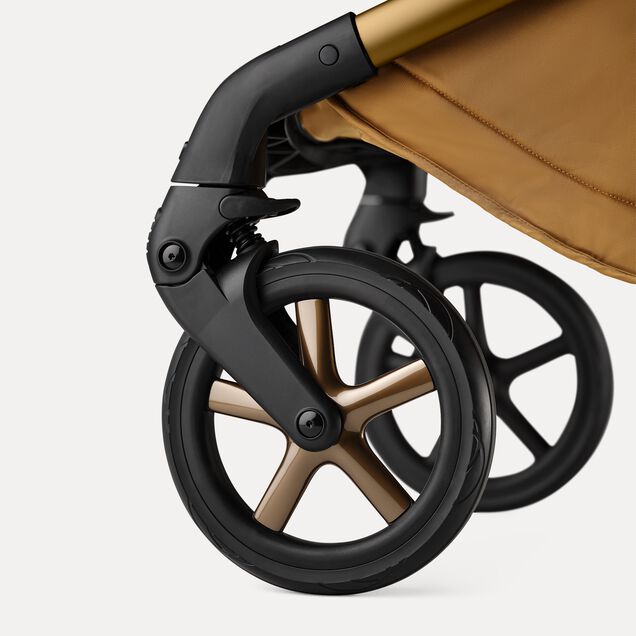 A close up of the wheels of the Bugaboo Fox 5 Noir Limited Edition Amber Glow. The wheel caps have polished rims. - Main Image Slide 12 of 15