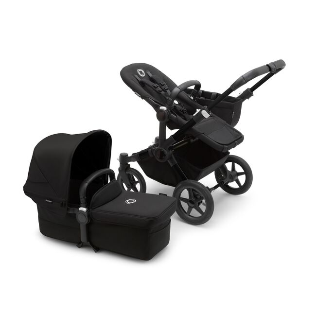 Bugaboo Donkey 5 Mono seat stroller with black chassis and midnight black fabrics, plus bassinet with midnight black sun canopy.