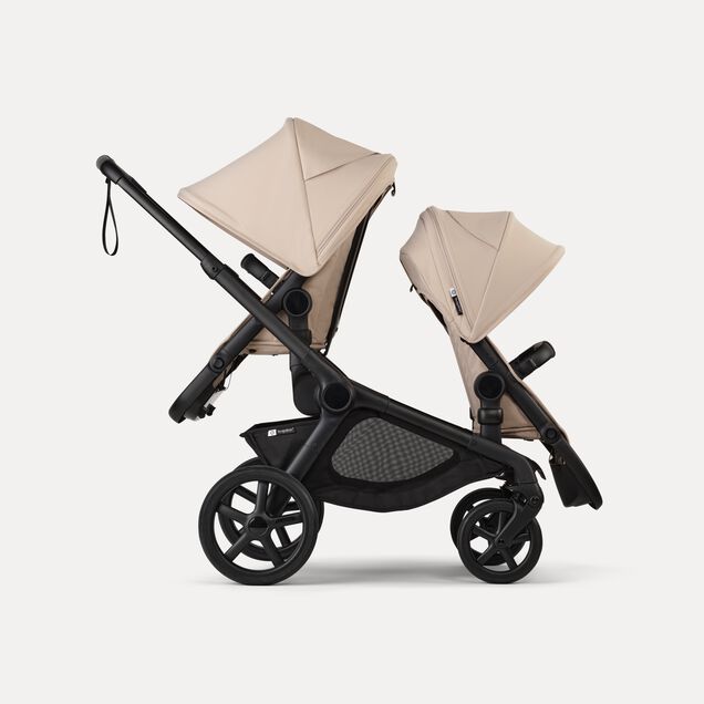 Side view of Bugaboo Kangaroo 2-in-1 tandem stroller with two seats, one facing parent and the other facing the world, with Desert Taupe fabrics and Desert Taupe sun canopies. - Main Image Slide 4 of 18