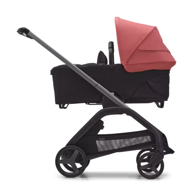 Zijaanzicht van de Bugaboo Dragonfly kinderwagen met wieg met graphite onderstel, midnight black bekleding en sunrise red zonnekap. - Main Image Slide 3 van 16