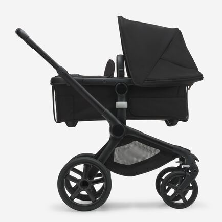 Side view of the Bugaboo Fox 5 bassinet stroller with black chassis, midnight black fabrics and midnight black sun canopy.