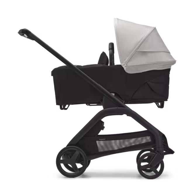 Zijaanzicht van de Bugaboo Dragonfly kinderwagen met wieg met black onderstel, midnight black bekleding en misty white zonnekap. - Main Image Slide 3 van 16