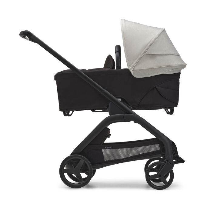 Side view of the Bugaboo Dragonfly bassinet stroller with black chassis, midnight black fabrics and misty white sun canopy.