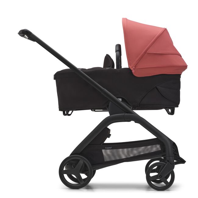 Side view of the Bugaboo Dragonfly bassinet stroller with black chassis, midnight black fabrics and sunrise red sun canopy.