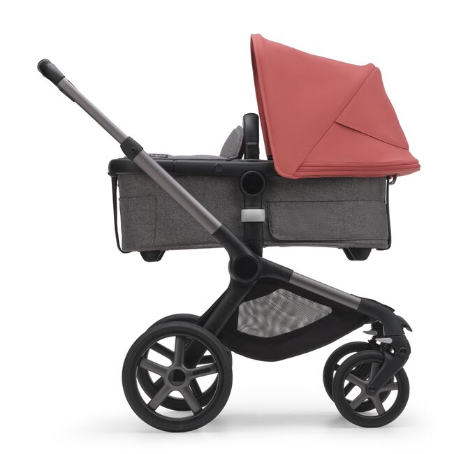 Side view of the Bugaboo Fox 5 bassinet stroller with graphite chassis, grey melange fabrics and sunrise red sun canopy. - Main Image Slide 3 of 16
