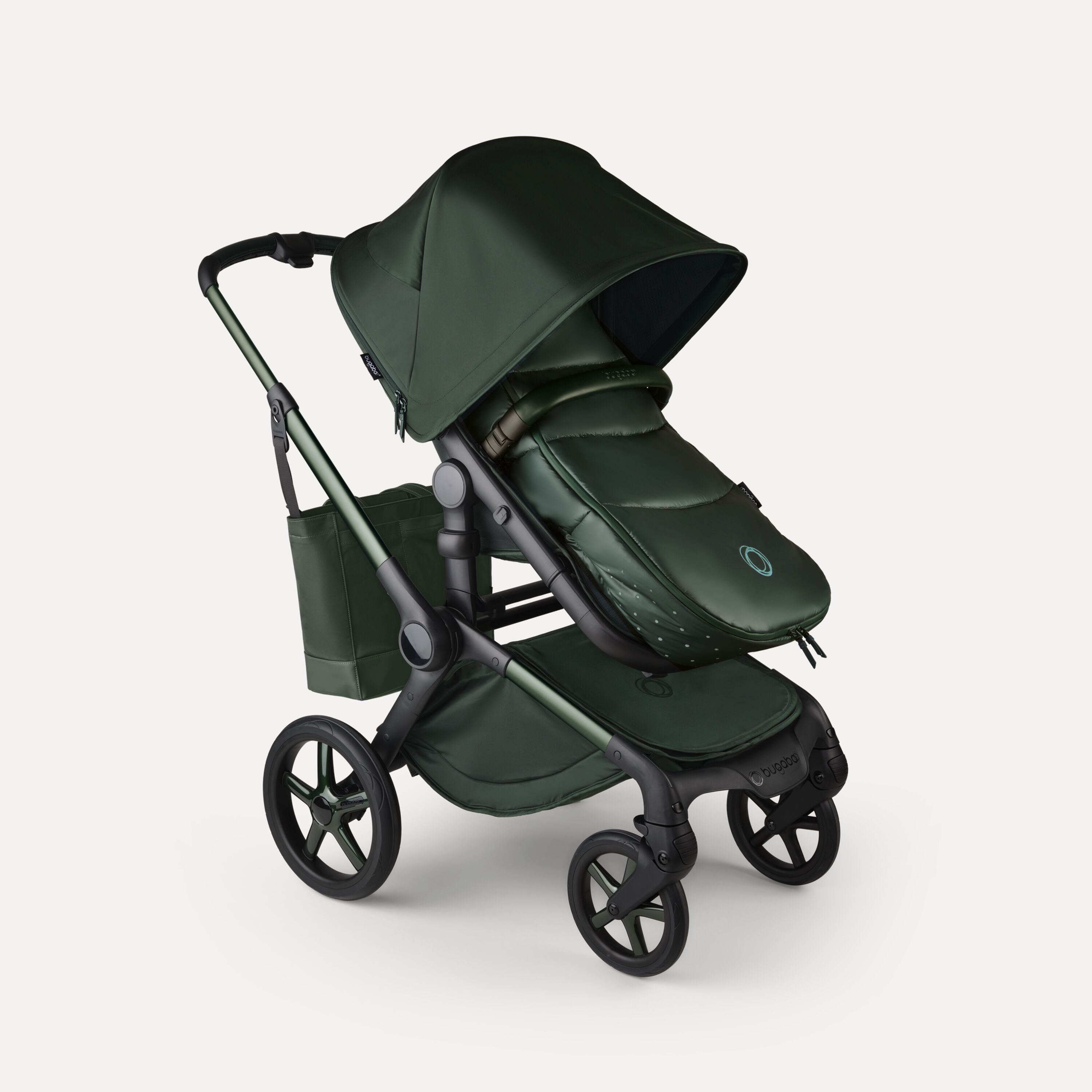 A Bugaboo Fox 5 Noir Limited Edition stroller with a footmuff and changing bag, all in the Midnight Green colorway. - Main Modal Image Slide 15 of 15