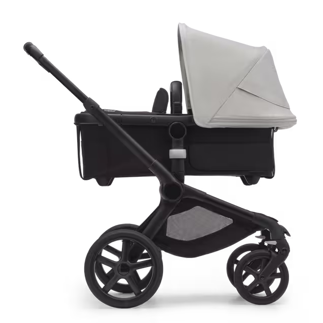 Side view of the Bugaboo Fox 5 bassinet stroller with black chassis, midnight black fabrics and misty white sun canopy. - Main Image Slide 2 of 12