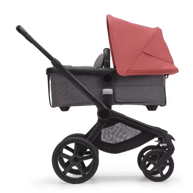 Side view of the Bugaboo Fox 5 carrycot pushchair with black chassis, grey melange fabrics and sunrise red sun canopy. - Main Image Slide 2 of 13